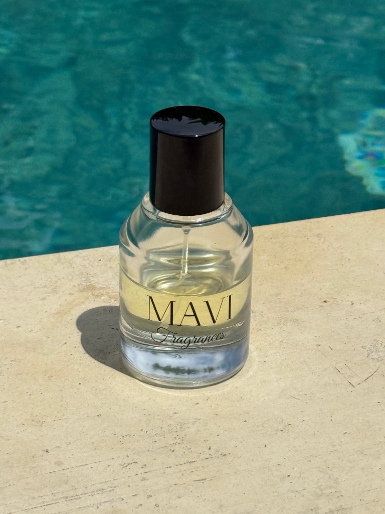 Mavi Fragrances bottle on a poolside stone edge