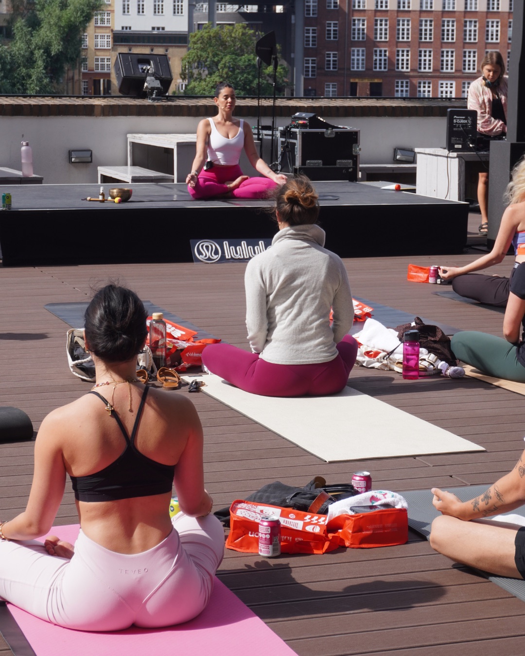 Rooftop techno yoga class with lululemon branding on stage